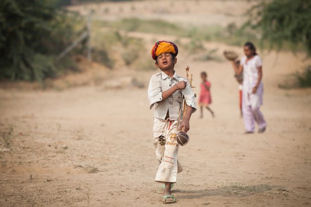 This boy was sent out with a turban and a ravanhatta(musical instrument) to attract tourists and make a living. 